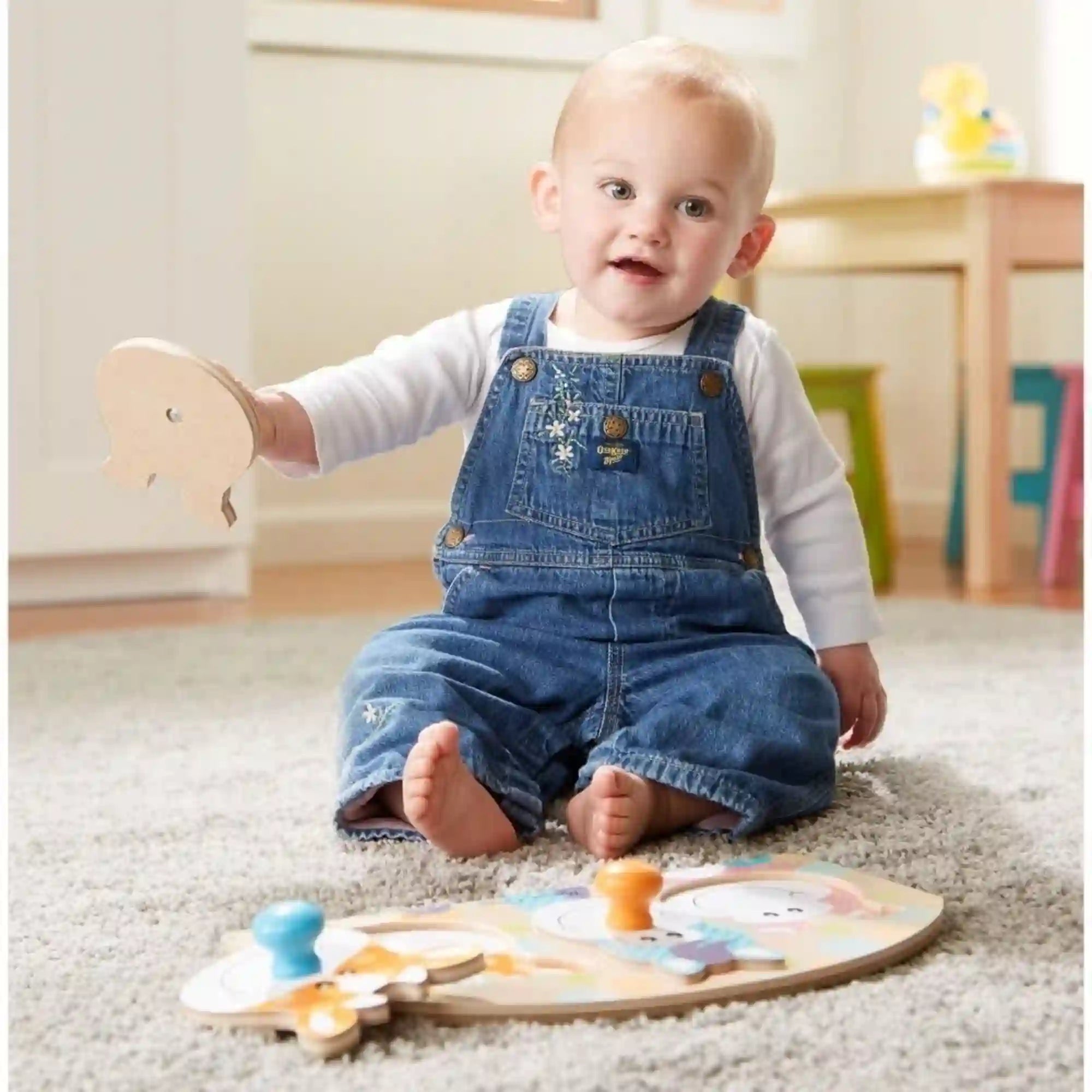 Melissa & Doug First Play farm óriás gombos puzzle használat közben, ahol egy kisgyermek a szőnyegen ülve illeszti a fa puzzle darabokat.