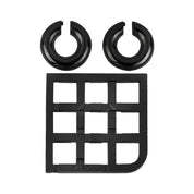 A Cast Duet puzzle darabokra szedve: két fényes fekete fémgyűrű és a négyzethálós alap külön elrendezve.