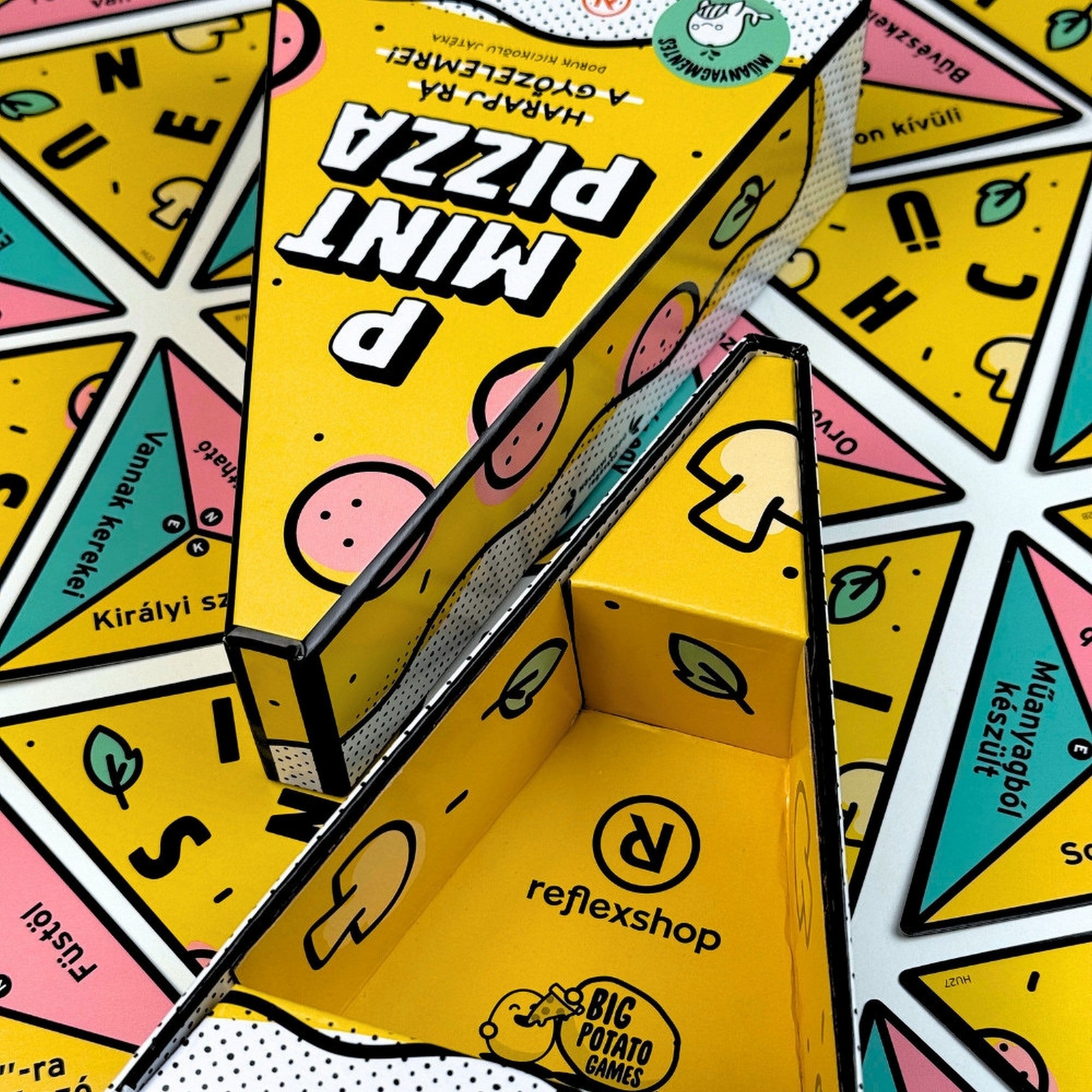 P Mint Pizza társasjáték dobozának belső kialakítása felnyitva, pizza szelet formájú tárolóval, sárga színű belső grafikával, Reflexshop és Big Potato Games logóval.