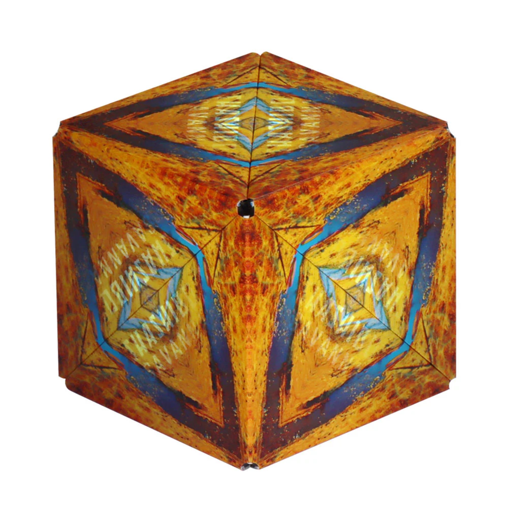 Első kép: A Shashibo: Savanna mágneses kocka hatszög formában, sárga, narancs és kék színekben, absztrakt, afrikai tájat idéző mintával.