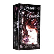 A képen a Tarot Favole kártyapakli doboza látható, melyet Victoria Francés gótikus stílusú illusztrációi díszítenek. A doboz közepén egy finoman kidolgozott portré szerepel: egy lehajtott fejű nő, akit sötét, göndör haj, lila virágok és egy lila pillangó vesz körül. A háttér fekete alapon díszes, csipkeszerű mintákkal van keretezve, ami még inkább kiemeli a melankolikus, romantikus hangulatot. A „Tarot Favole” felirat elegáns, fehér kalligrafikus betűkkel íródott a doboz elején és oldalán is. 