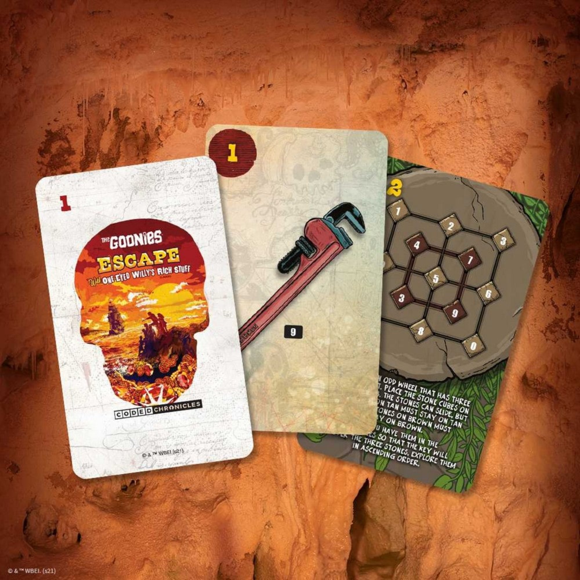 Három kártya a The Goonies: Escape játékból: a dobozkép, egy csavarkulcs és egy fejtörőt ábrázoló rejtvénykártya.