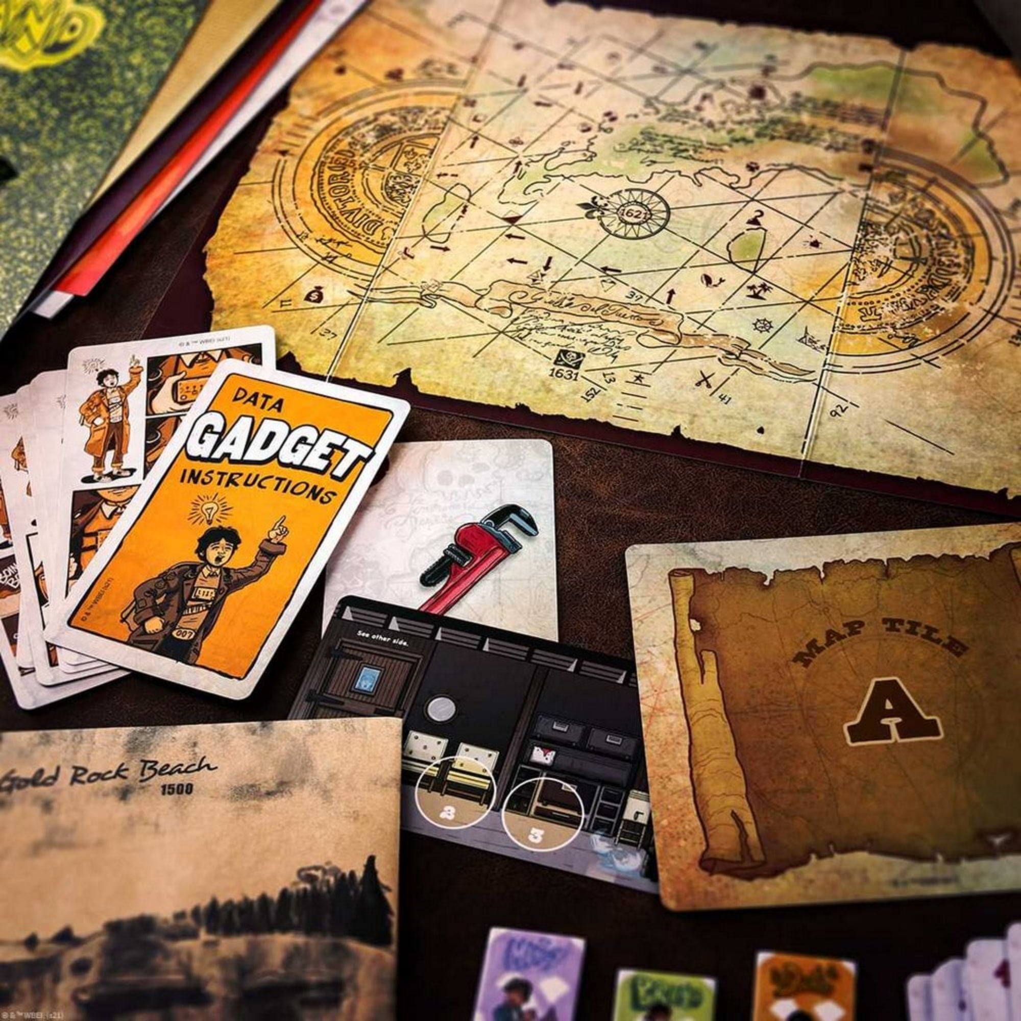 Részletgazdag fotó a The Goonies: Escape játékból, térképrészletekkel, Gadget instrukciókártyával és játékelemekkel.