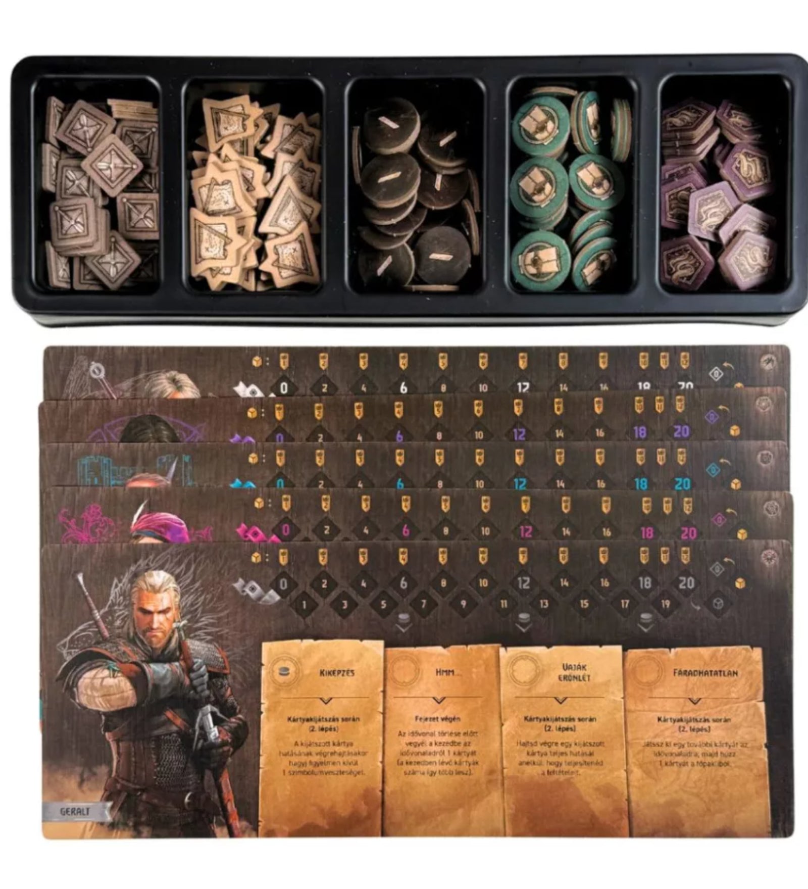 A The Witcher: A végzet útja társasjáték alkatrészei, köztük karaktertáblák Geralt portréjával és különféle jelölők rendezve egy tálcában