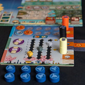 A fehér várkastély: Párbaj játékos táblája kék, fekete, sárga és narancssárga jelölőkkel és különböző nyomtatott szimbólumokkal.