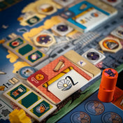 A fehér várkastély: Párbaj tábla közelebbről, színes lapkákkal, ikonokkal és egy narancssárga fa jelölővel.