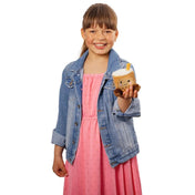 Boba tea plüss – kislány kezében tartott mosolygós, barna színű bubble tea formájú plüss játék fehér háttér előtt.