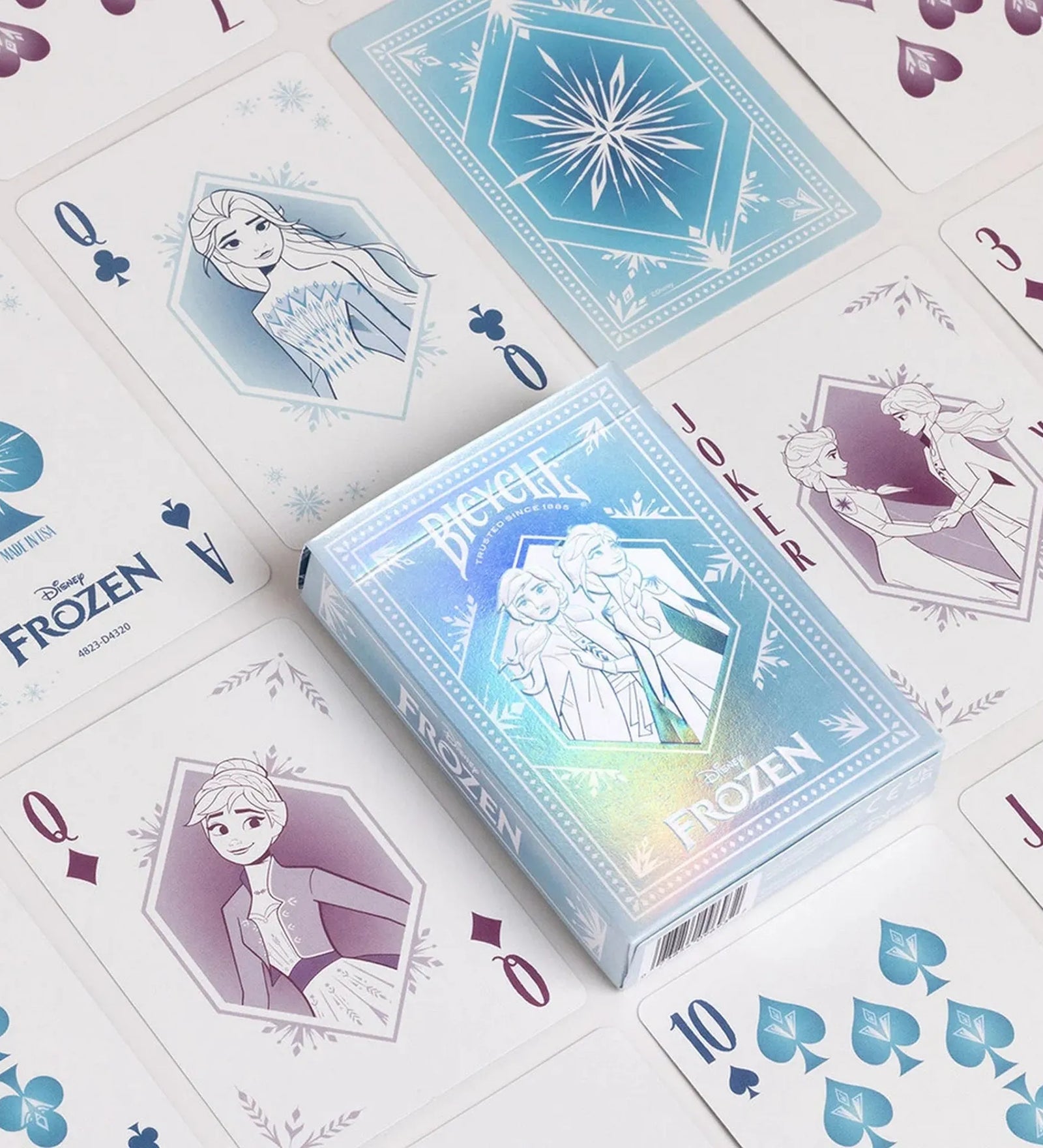 A Bicycle Disney Frozen kártyapakli doboza nyitva, körülötte a mesés grafikájú lapok – Elza és Anna illusztrációival, jégkristályos mintákkal díszítve.