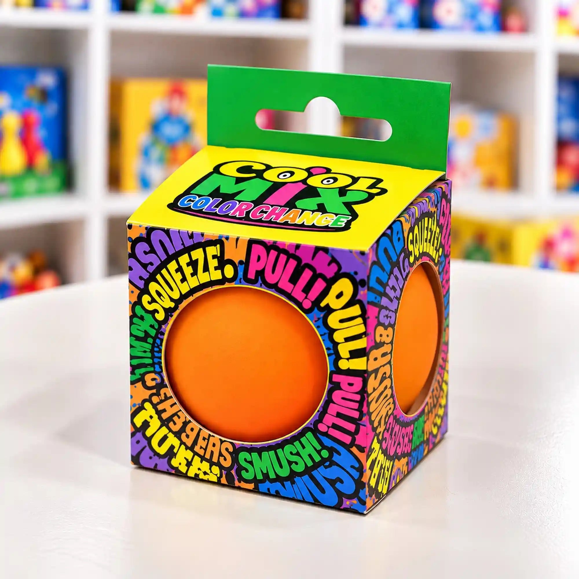 Cool Mix Squishy 7 cm stresszlevezető játék (narancssárga) – Narancssárga squishy labda színes mintázatú dobozban, elöl és oldalt kör alakú nyílással.