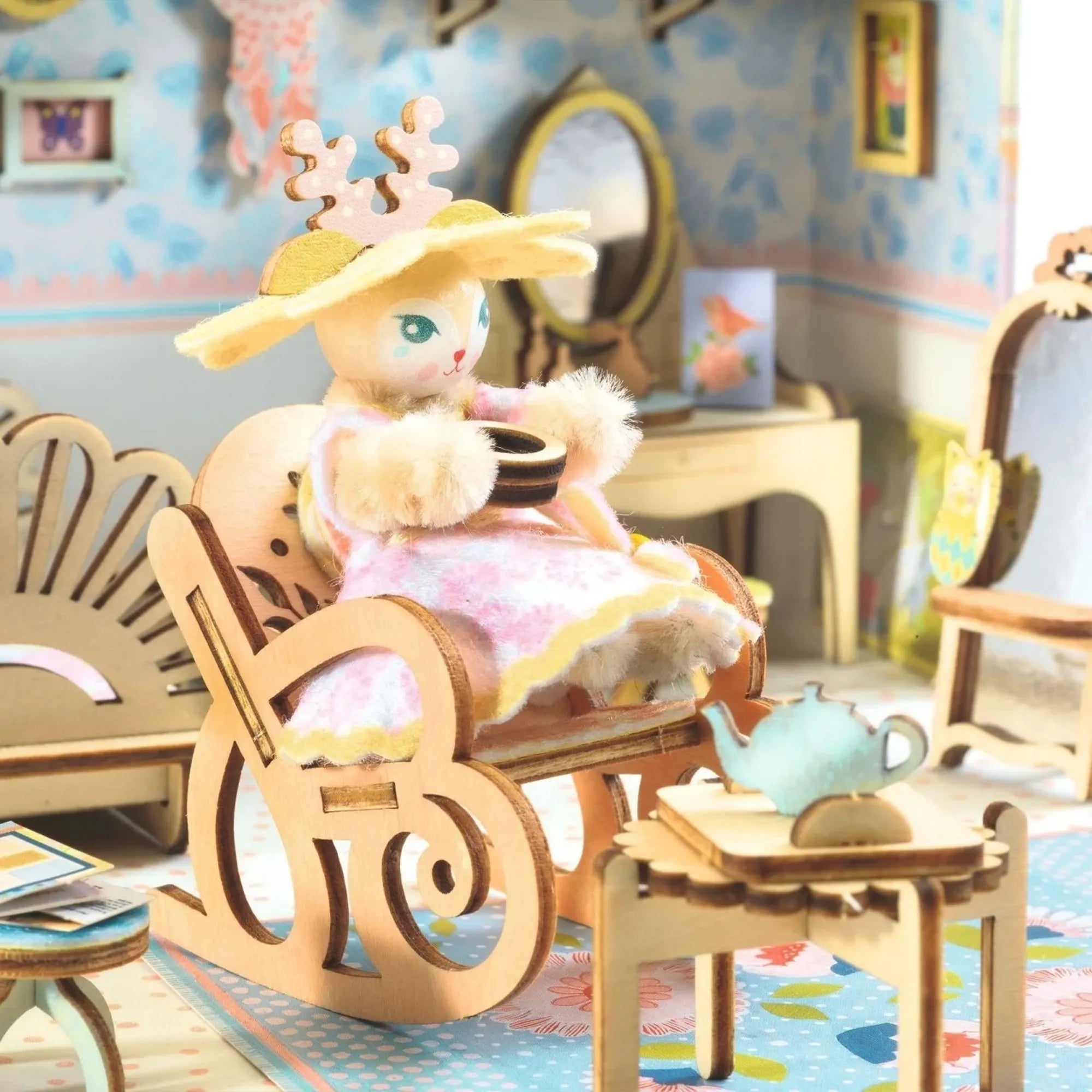 Djeco Csináld magad, Alba házikója – részletkép Alba figuráról hintaszékben, asztallal és teáskészlettel.