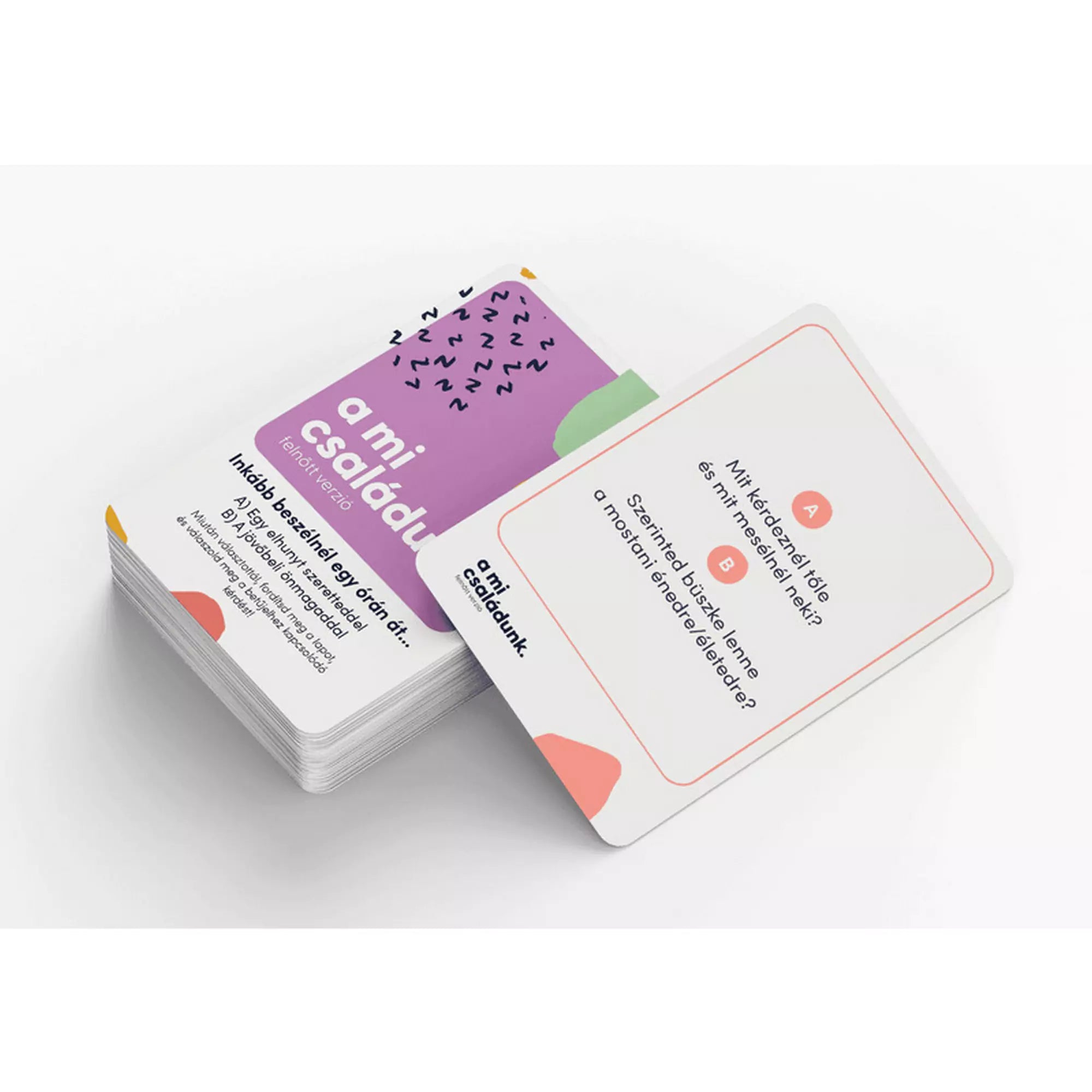 A mi családunk – felnőtt verzió társasjáték kártyapaklija, előtérben egy kérdéskártyával, amely mélyebb családi beszélgetésekre ösztönöz