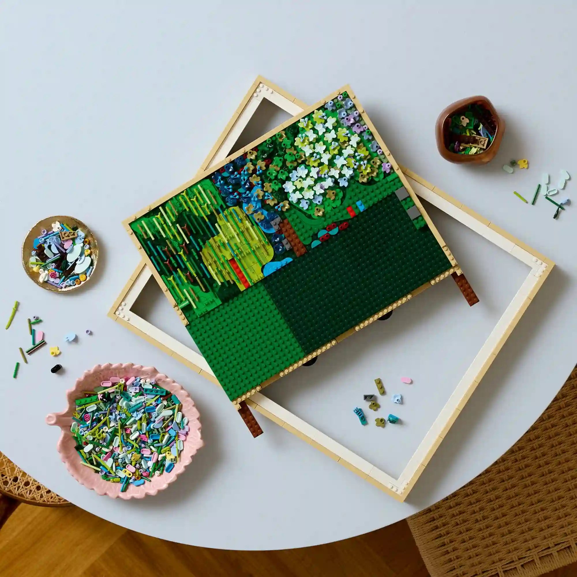 LEGO Art: Claude Monet Híd a vízililiomos tó felett 31220, 3179 darabos építés közbeni részlet, alaplap és színes elemek tálkákban.