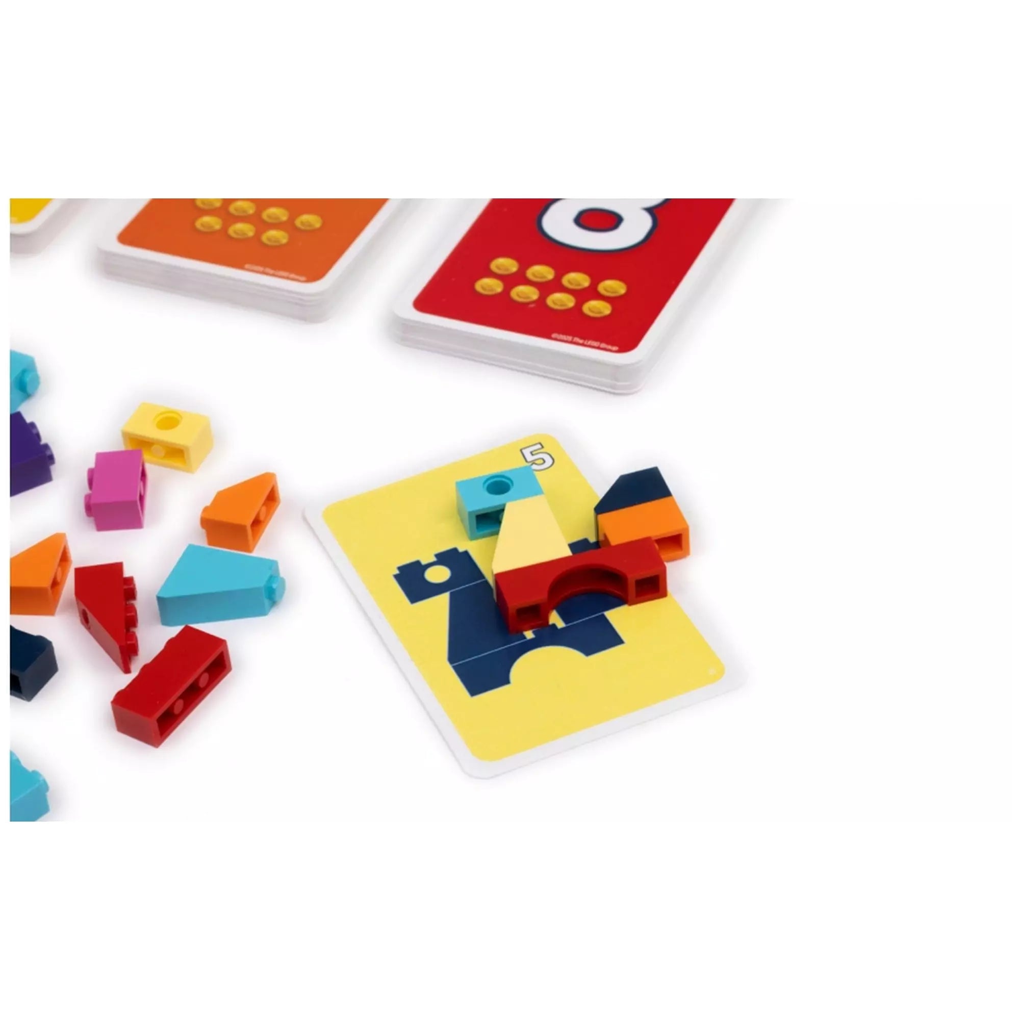 „LEGO Brick Like This játék közelről: sárga kártyára épített színes LEGO kockákból álló modell, mellette a játékelemek.”