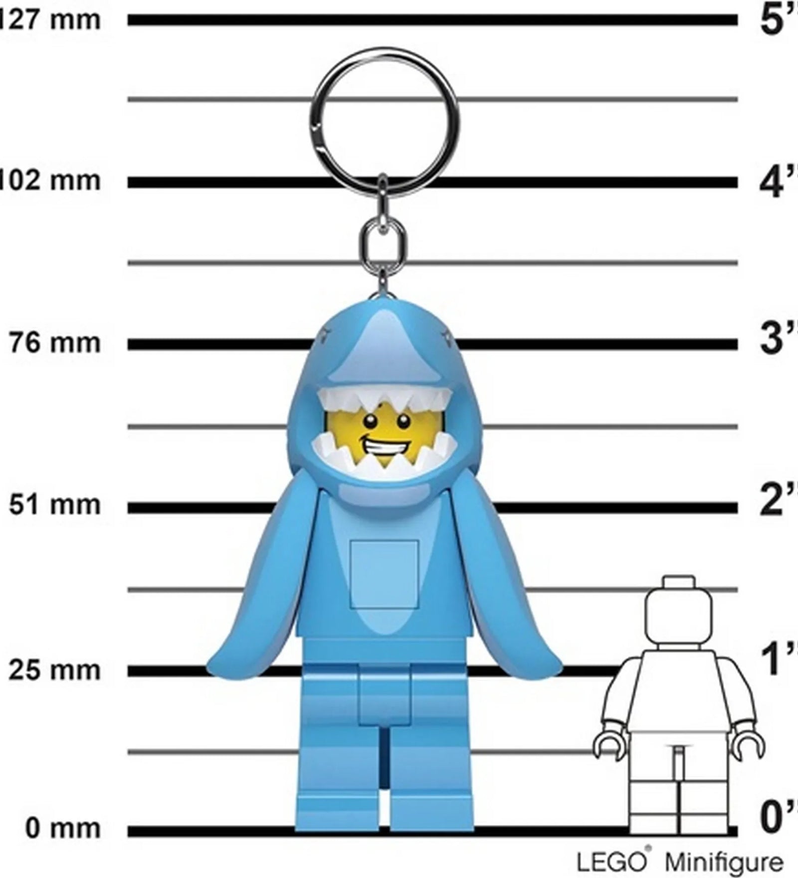 A képen a LEGO LED Shark Guy kulcstartó látható méretarányos háttér előtt, centiméter- és inch-skálával. A kulcstartó minifigura nagyobb, mint egy hagyományos LEGO minifigura.