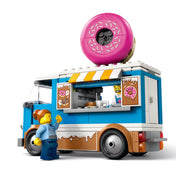 Oldalnézet a LEGO City Fánkárus büfékocsiról (60452), ahol egy eladó és egy vásárló minifigura látható – készen a finom falatok kiszolgálására.