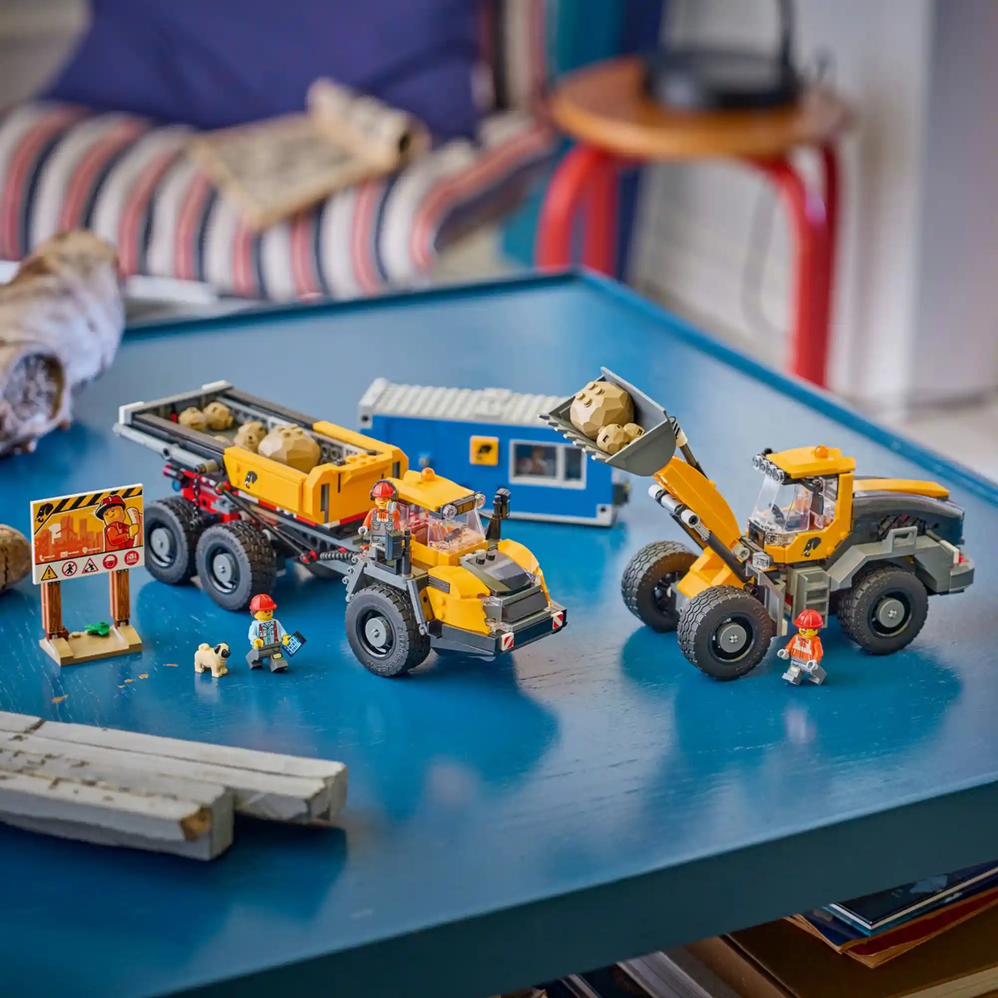 LEGO City Homlokrakodó és billenőplatós teherautó (60494) összeépített modellje dömperrel, homlokrakodóval, mobil irodával, munkás figurákkal és építkezési kellékekkel egy asztalon elrendezve.