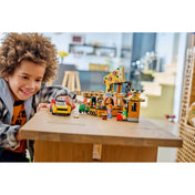 Gyermek játszik a LEGO City 60496 pizzériával, miközben a pizzakiszállító autót és az étterem elemeit használja.
