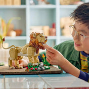 Gyermek játszik a LEGO Creator Fenséges oroszlán (31386) modelllel, miközben az oroszlán nyitható száját és mozgatható fejét vizsgálja.