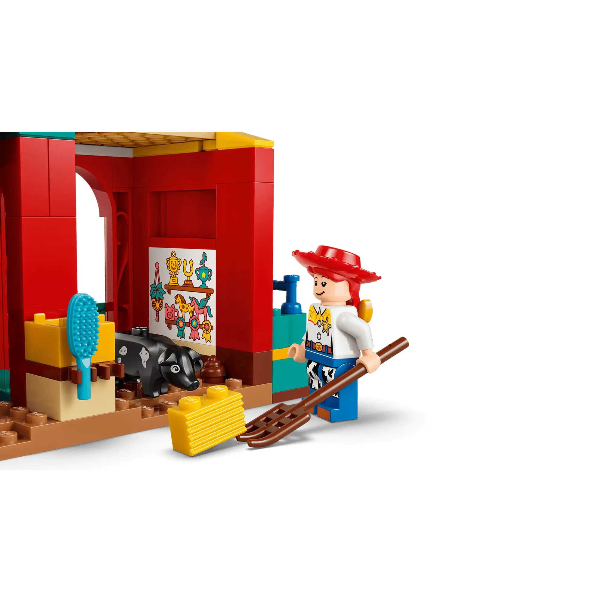 Jessie minifigura istállóban, kiegészítők: villa, széna, malac és díszített falrészlet LEGO Toy Story készletből