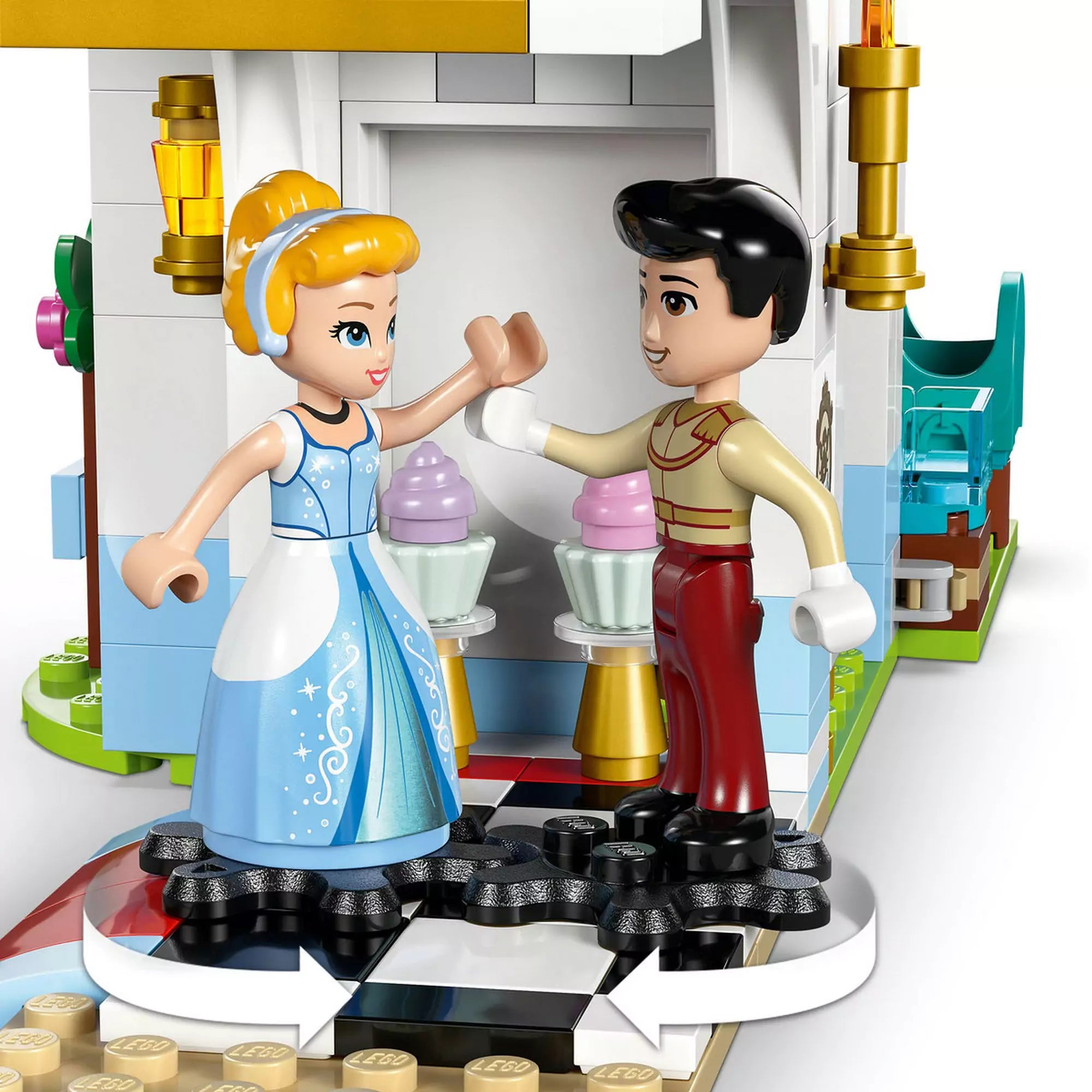 LEGO Disney Hamupipőke és a Szőke herceg a forgó padlón táncolnak a kastély tánctermében.