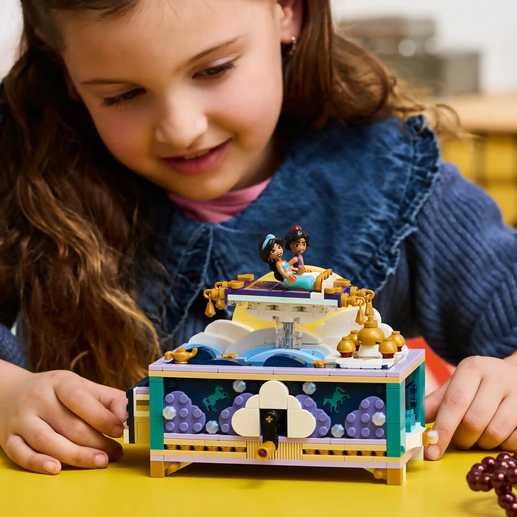 LEGO Disney: Jázmin ékszerdoboza 43295, 458 darabos készlet játék közben, ahol egy gyermek a forgatható repülő szőnyeggel és az interaktív ékszerdobozzal játszik.