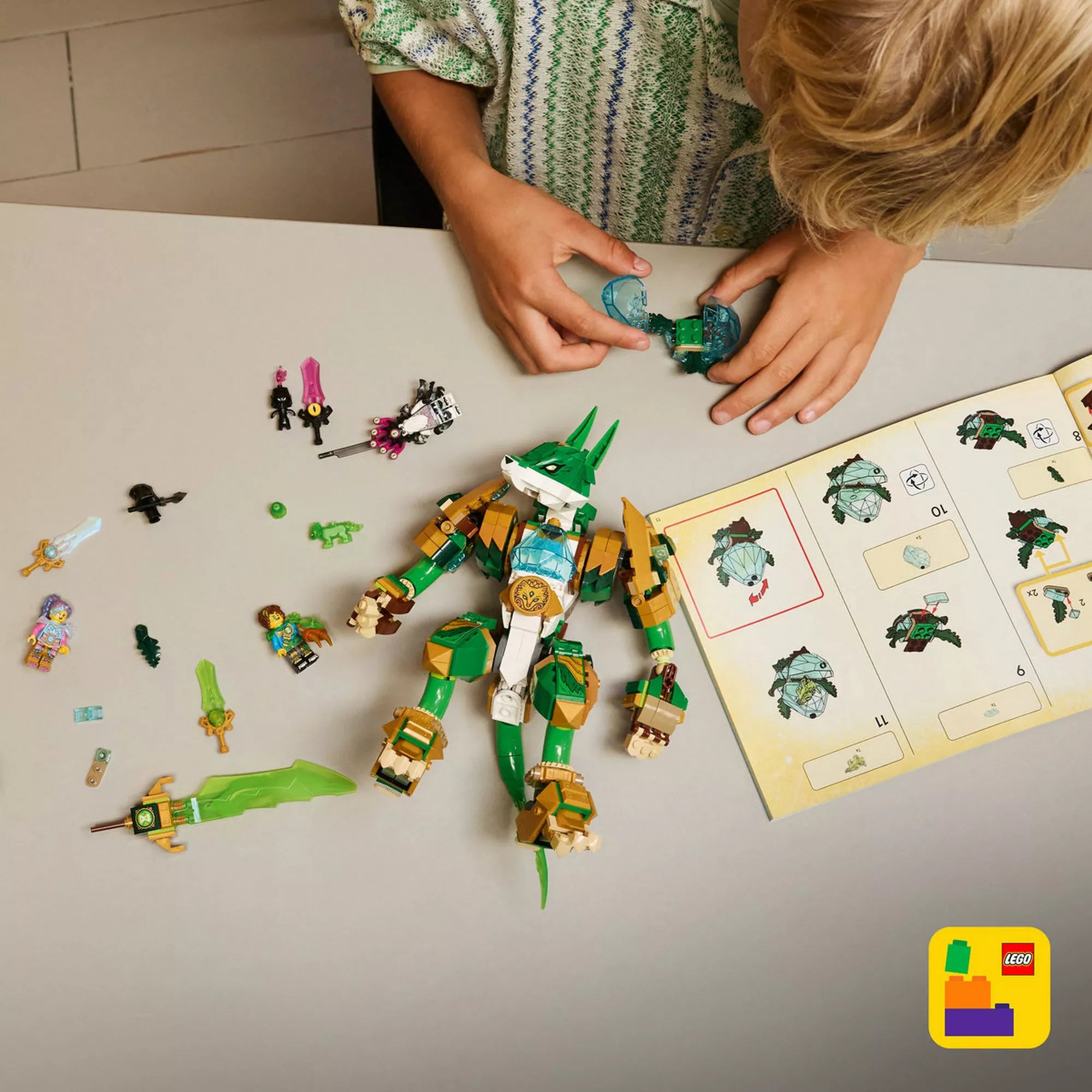 LEGO DREAMZzz 71508 Fox Guardian Mech építés közben, szétszedett alkatrészekkel, minifigurákkal és részletes építési útmutatóval az asztalon