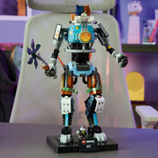 Megépített LEGO Fortnite KIT robotfigura asztalon kiállítva, mozgatható végtagokkal, részletgazdag mechanikus kialakítással és Fortnite témájú talapzattal.