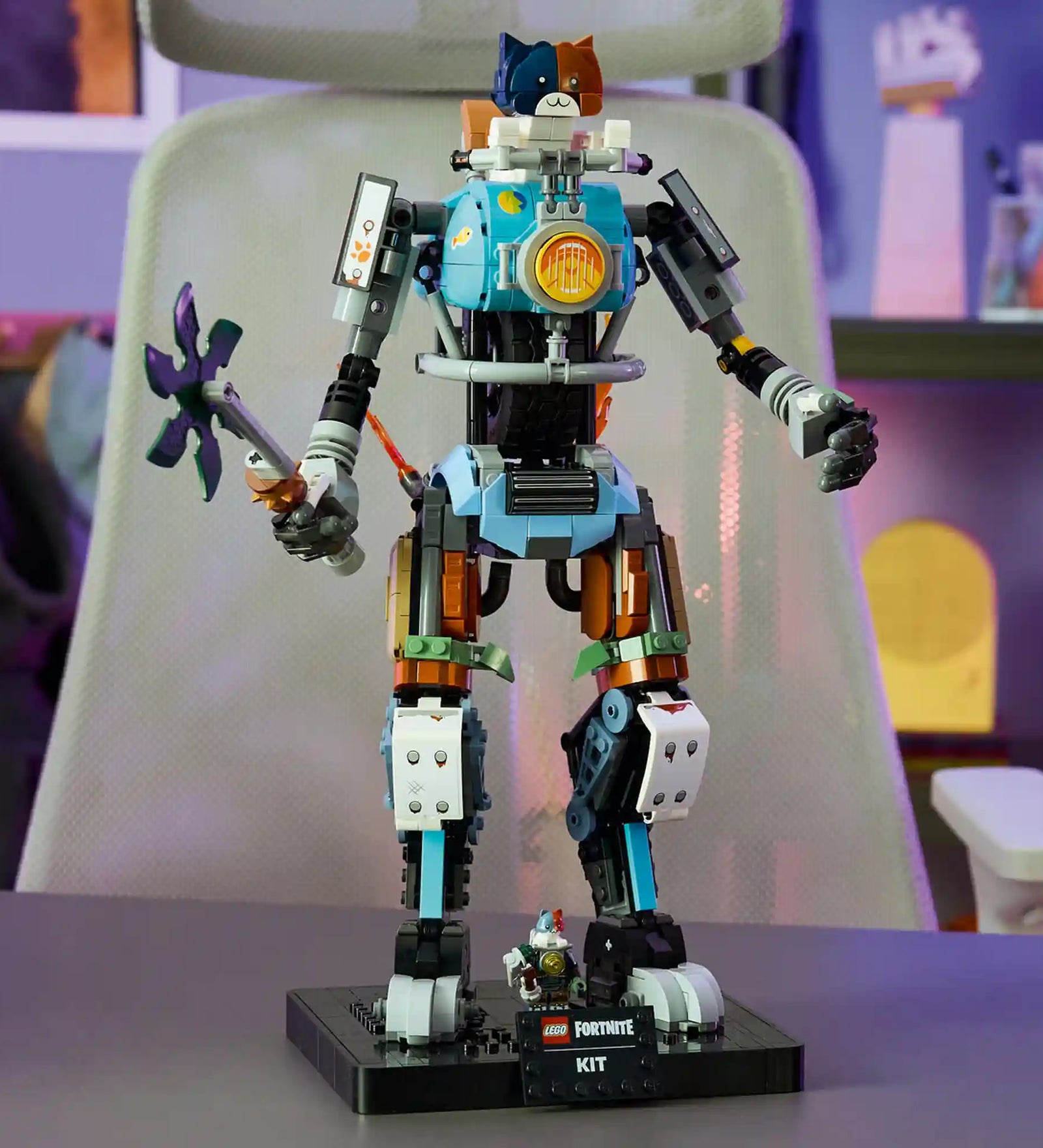 Megépített LEGO Fortnite KIT robotfigura asztalon kiállítva, mozgatható végtagokkal, részletgazdag mechanikus kialakítással és Fortnite témájú talapzattal.