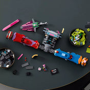 LEGO Fortnite Mecha Team Leader (77078) szétszerelt elemei asztalon, minifigurával, karddal és építőelemekkel.