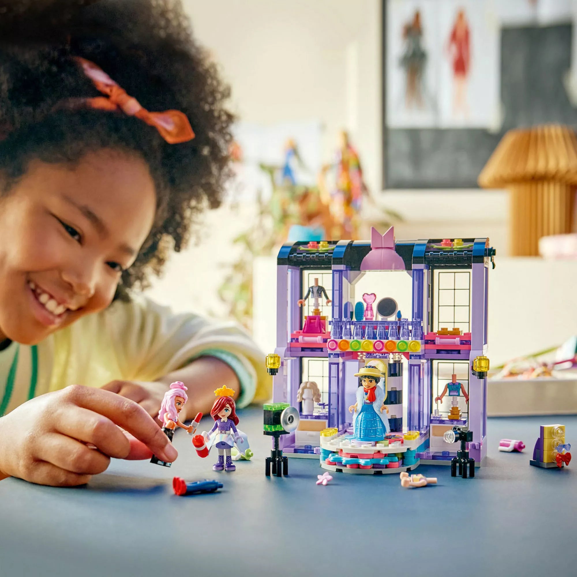 Gyermek LEGO Friends Heartlake City divatbemutató készlettel játszik, a kifutón bemutatott figurákkal és divatos kiegészítőkkel egy világos szobában.