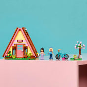 LEGO Friends Glamping kabin 42682 készlet a figurákkal, kerékpárral, virágzó fával és szabadtéri kiegészítőkkel.