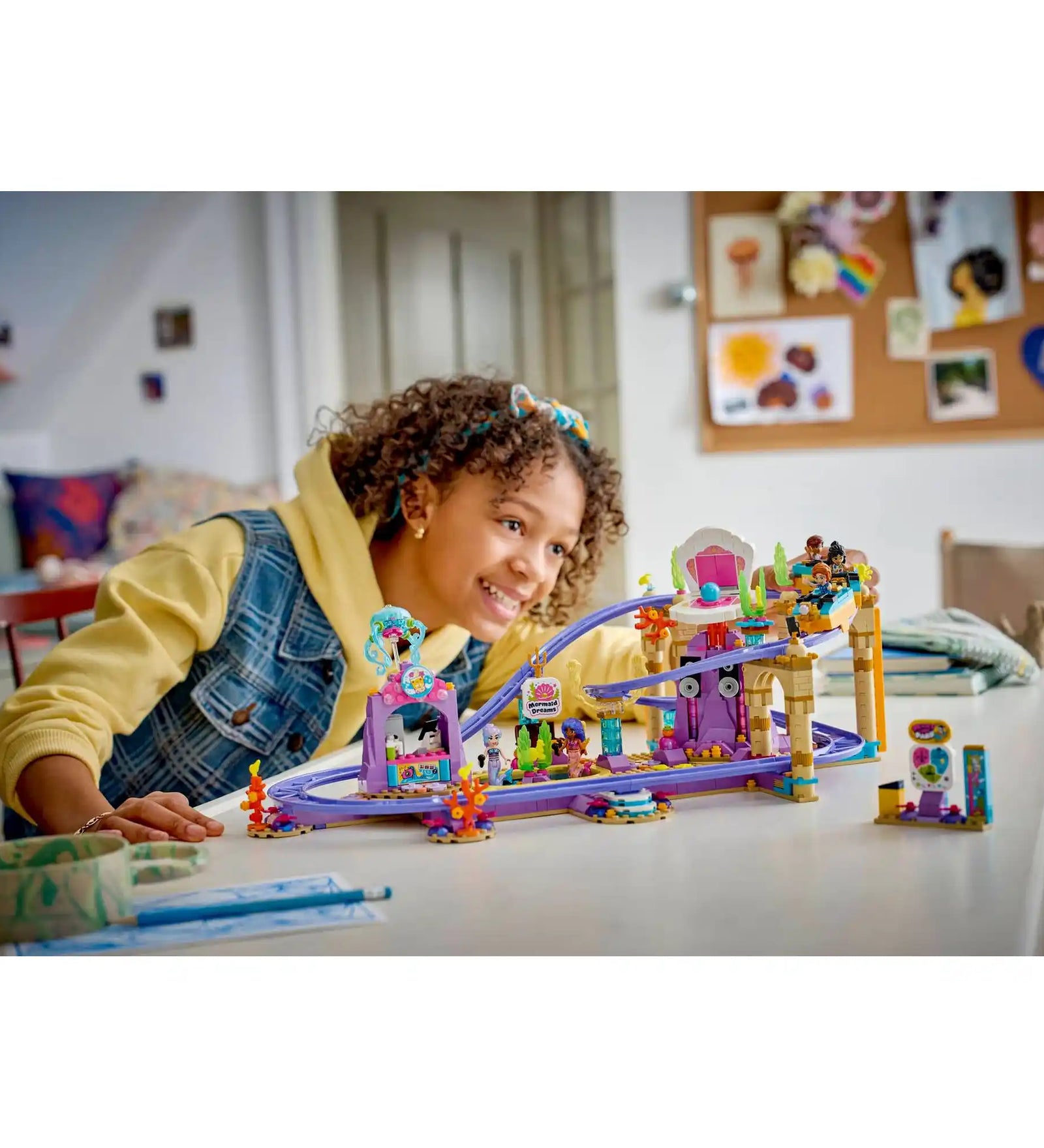 LEGO Friends: Hableányos hullámvasút 42703, 864 darabos készlet játék közben, ahol egy gyermek a színes víz alatti vidámparki hullámvasút modelljét nézi.