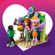 LEGO Friends: Körhinta virágokkal és tündérekkel 42702, 321 darabos készlet minifigurái a virágos fotóállomásnál, fényképezőgéppel, lufival és tündérszárnyakkal.