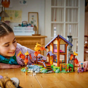 Gyermek játszik a LEGO Friends Otthonos kabin az őszi erdőben készlettel, miközben az erdei környezetet és a figurák kalandjait fedezi fel.