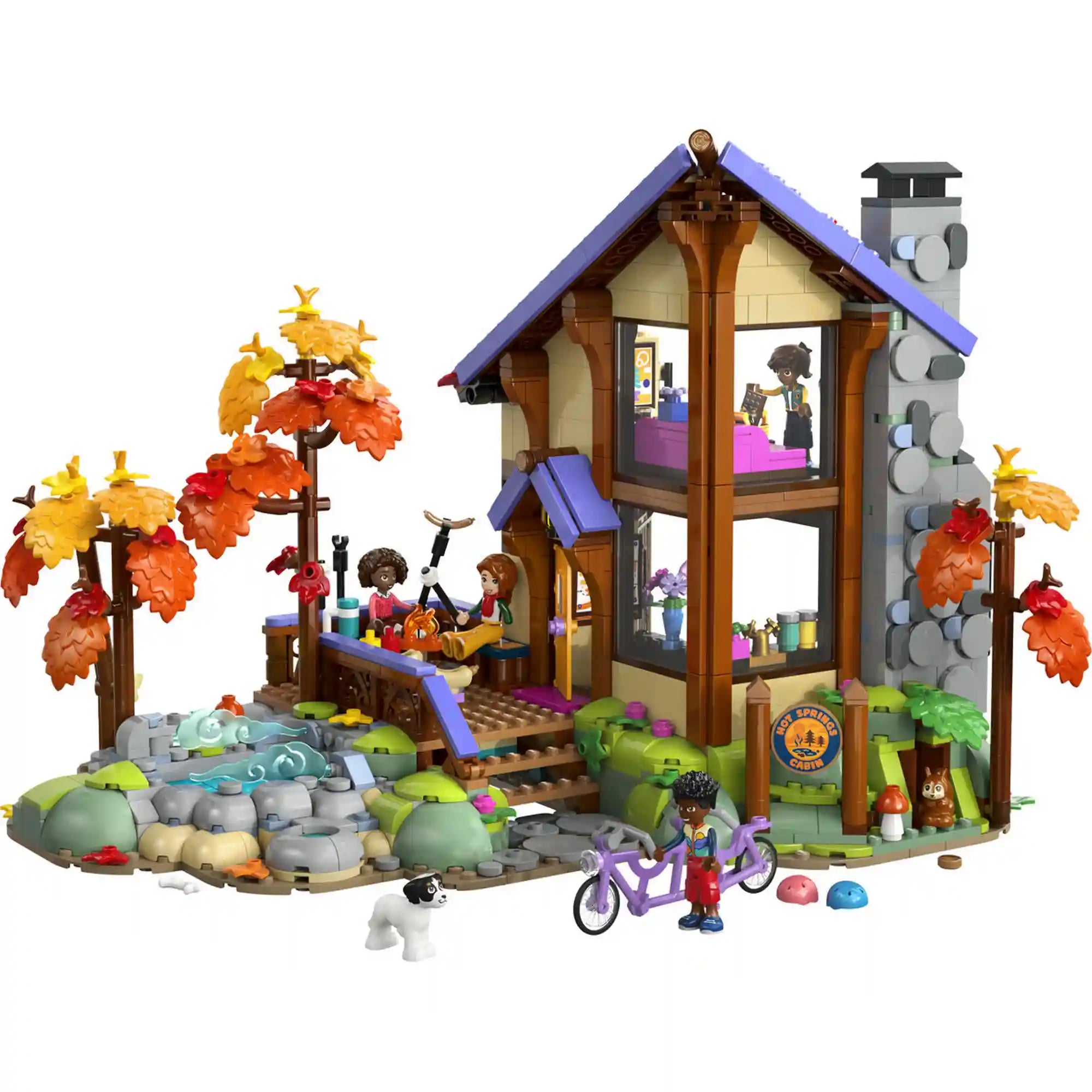 LEGO Friends Otthonos kabin az őszi erdőben megépített modellje kétszintes faházzal, terasszal, patakkal, őszi fákkal, kutyával és tandemkerékpárral.