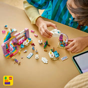 LEGO Friends Unikornisos kávézó építése közben, szétszórt elemekkel és részletekkel az asztalon