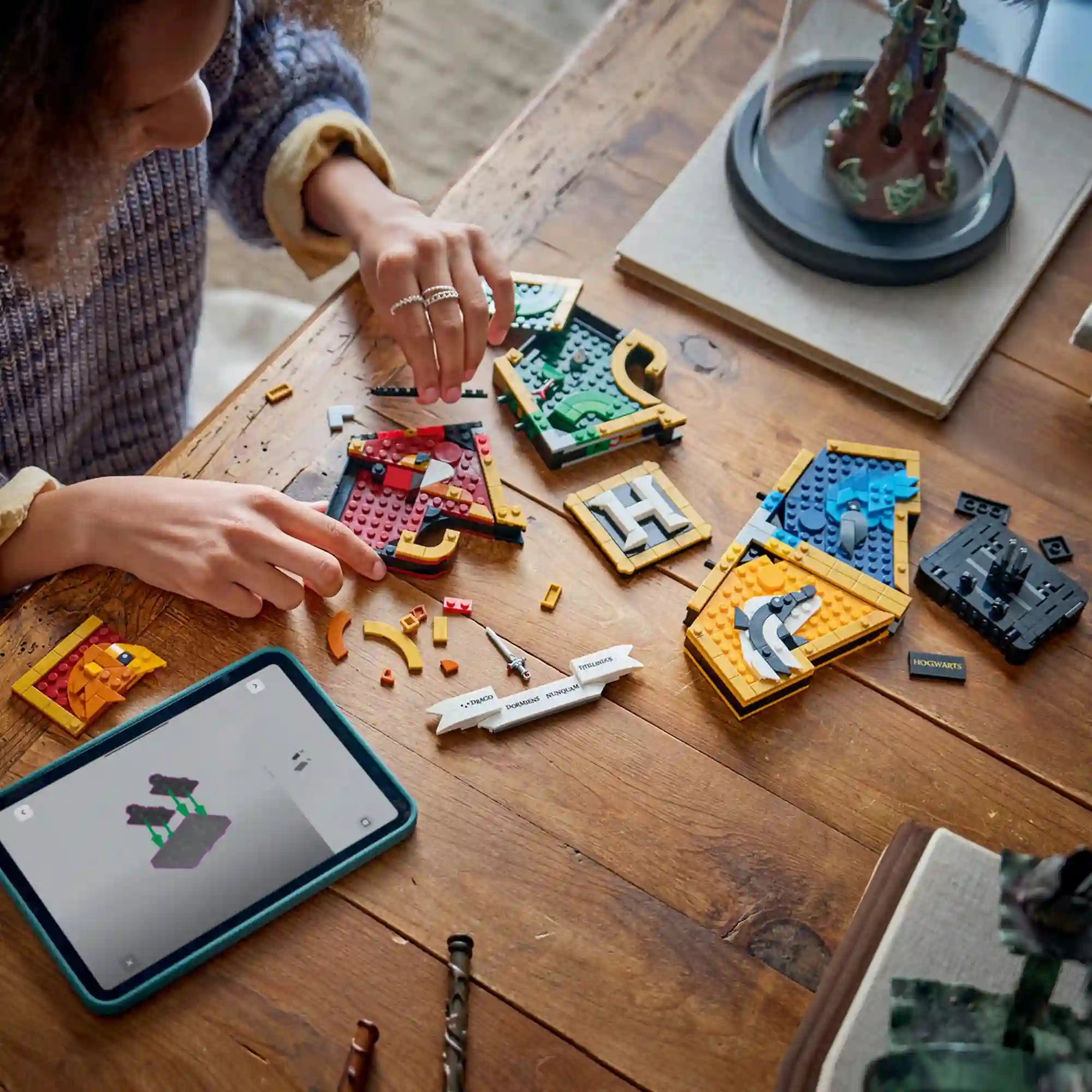 LEGO Harry Potter: A Roxfort címere 76462, 545 darabos készlet építési folyamata, szétszedett címerpanelekkel, digitális építési útmutatóval és részletes LEGO elemekkel.