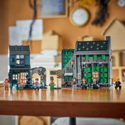 LEGO Harry Potter 76471 életkép, ahol a Zsebpiszok köz üzletei egy asztalon kiállítva láthatók a minifigurákkal és Ron patrónusával.