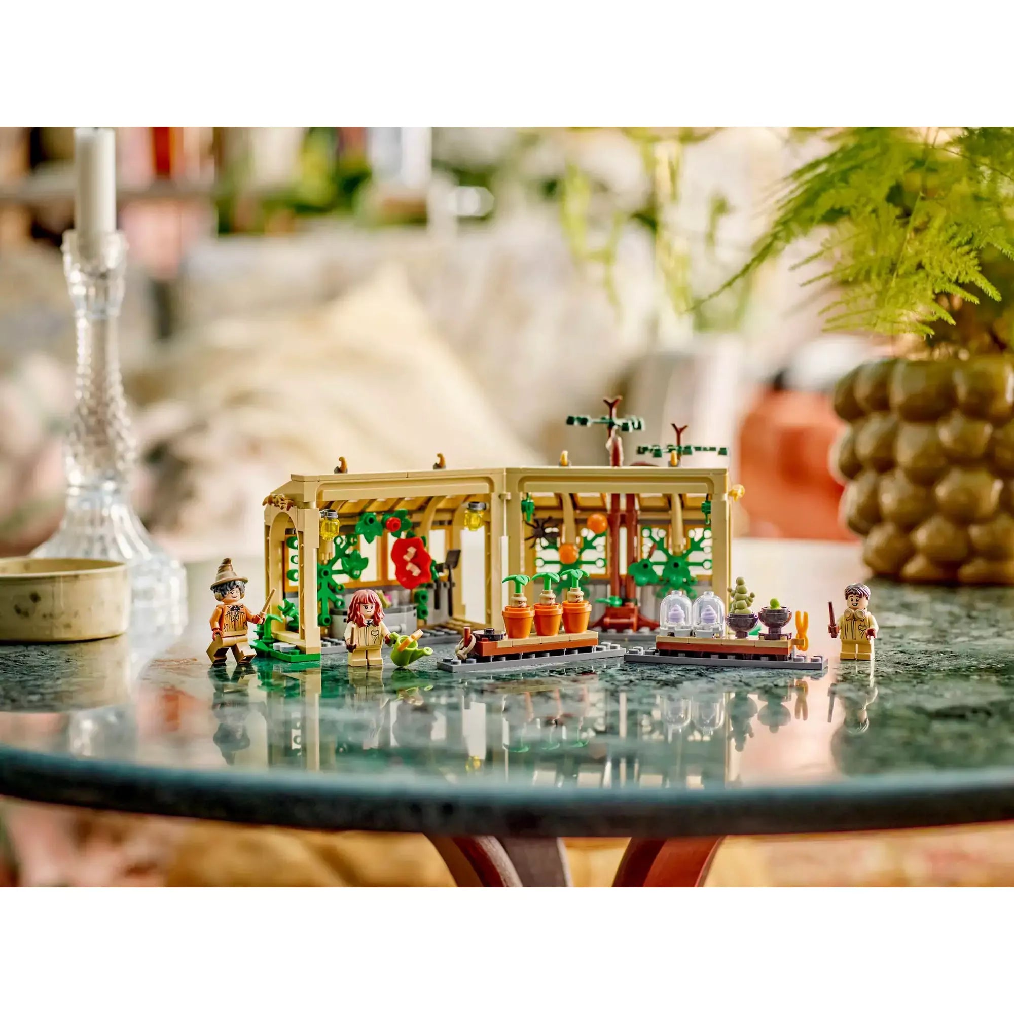 LEGO Harry Potter Roxfort kastély: Gyógynövénytanóra 76445 készlet egy asztalon berendezve, karakterekkel és kiegészítőkkel.