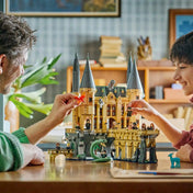LEGO Harry Potter Roxfort kastély Keleti szárny 76473 életkép, ahol apa és gyermek játszik a részletes kastélymodellel.