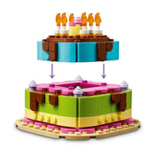 A LEGO 40815 Születésnapi torta nyitható felső része, amely a belső tárolórekeszt és a cserélhető díszítőelemeket mutatja be.