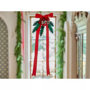 Egy karácsonyi LEGO dekoráció piros szalaggal és zöld levelekkel, ablak elé függesztve, amely a LEGO® Karácsonyi asztali dekoráció (40743) szett része.