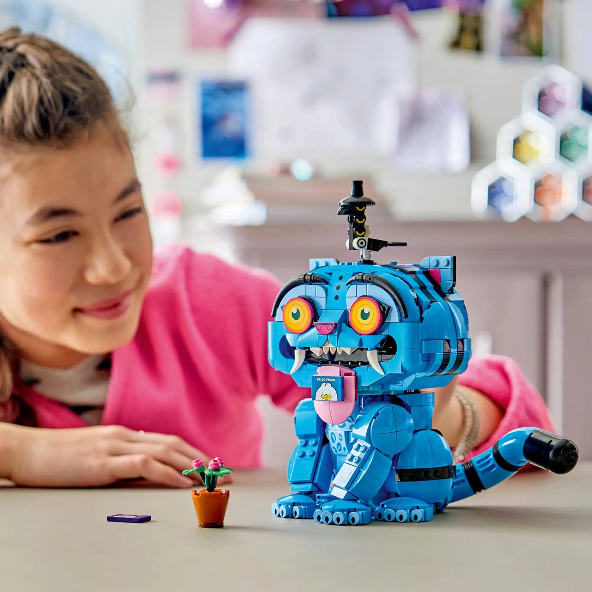 A LEGO KPop Demon Hunters: Derpy tigris és Sussie madár 72537 készlettel játszó gyermek, a Derpy tigris figurájának mozgatható nyelvével és virágcserép kiegészítőjével.