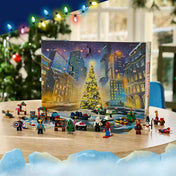 A LEGO Marvel adventi naptár kinyitott doboza, előtte szuperhős minifigurák, apró járművek és ünnepi építmények.
