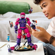 Gyermek játszik a LEGO Marvel 76348 mozgatható Őrszem robotjával és minifiguráival.