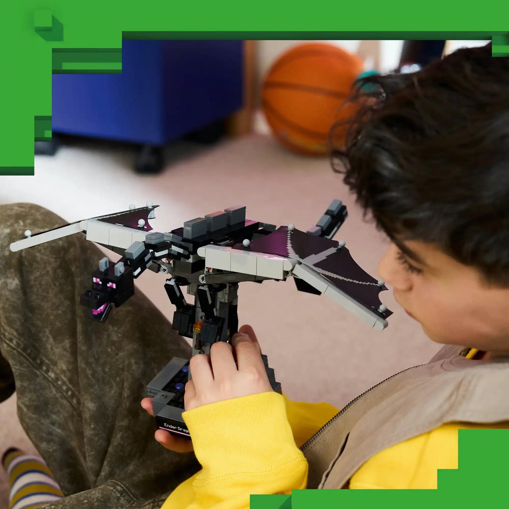 Fiú kezében a LEGO Minecraft Végzetsárkány modell, amelynek mozgatható szárnyai és feje dinamikus pózok kialakítását teszik lehetővé.