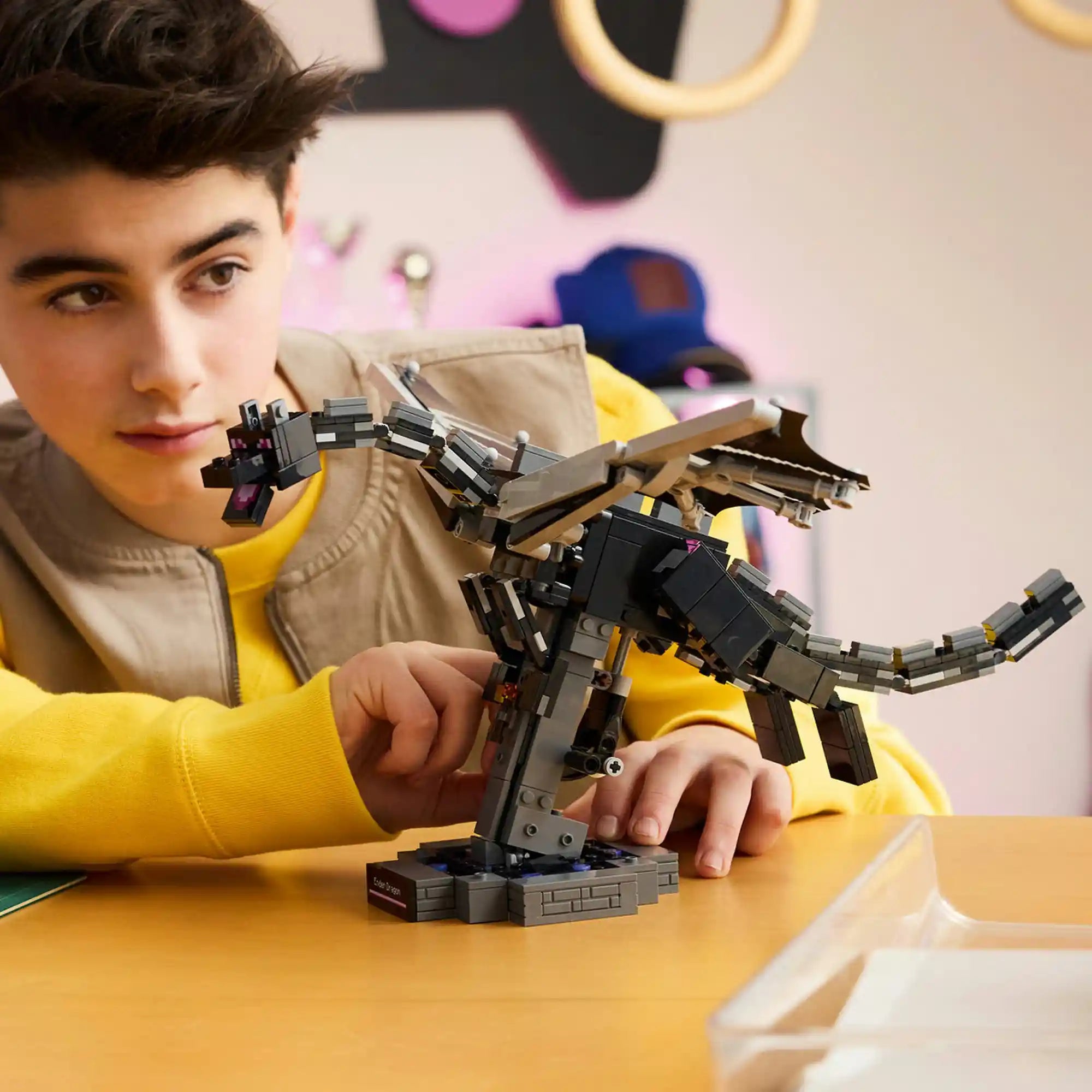 Fiatal Minecraft rajongó a megépített LEGO Végzetsárkány modellt vizsgálja. A részletgazdag sárkány állványon helyezkedik el, miközben a gyermek a mozgatható funkciókat próbálja ki.