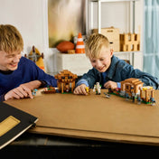 LEGO Minecraft 21596 falusi támadás jelenet gyerekek játék közben, házakkal, találkozási ponttal, vasgólemmel és Minecraft karakterekkel.