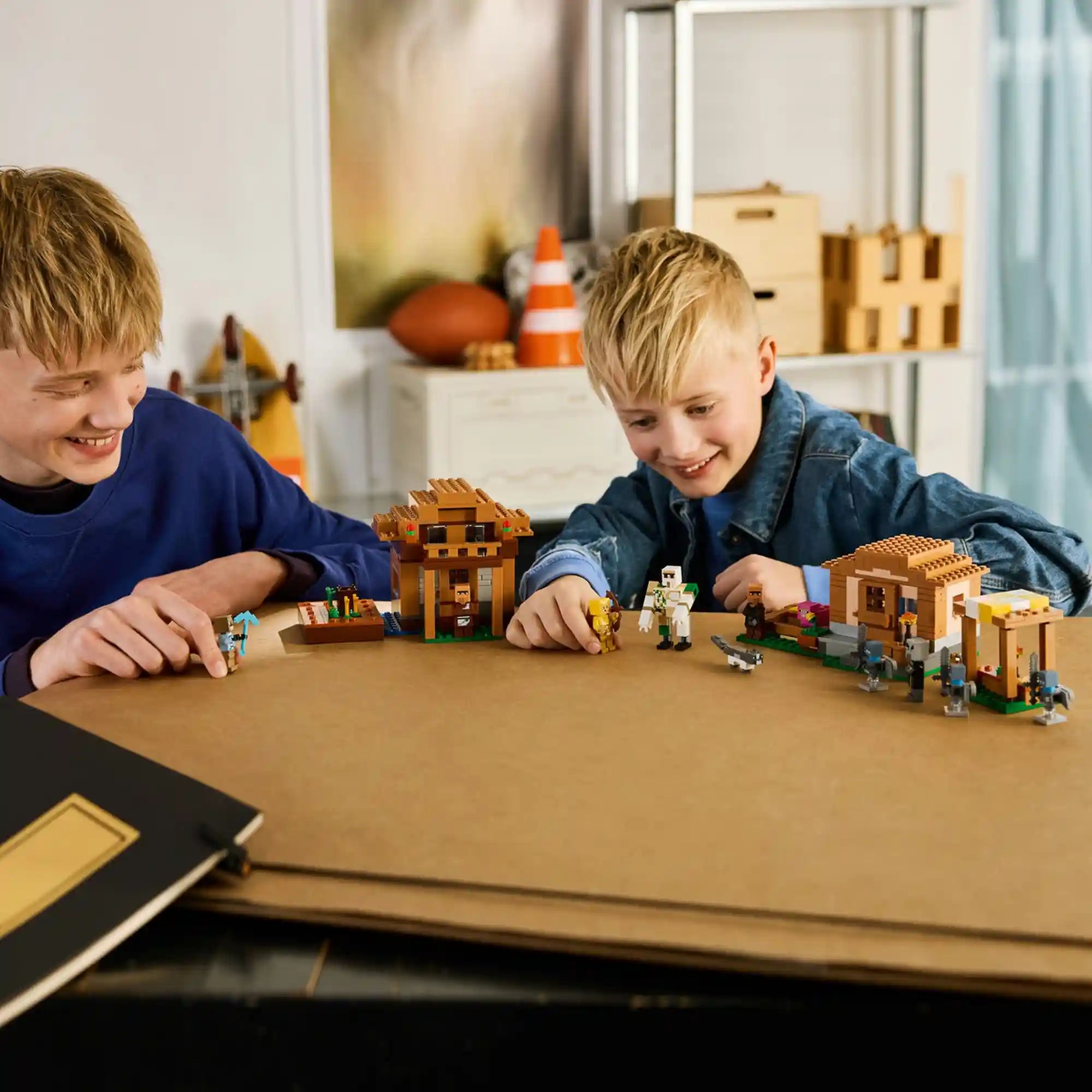 LEGO Minecraft 21596 falusi támadás jelenet gyerekek játék közben, házakkal, találkozási ponttal, vasgólemmel és Minecraft karakterekkel.