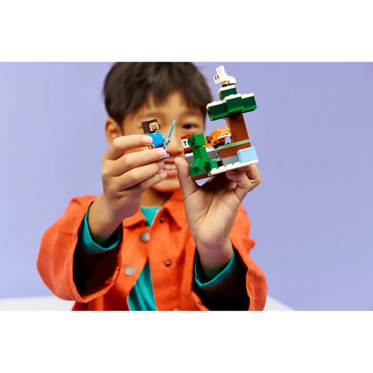 LEGO Minecraft Steve’s Taiga Adventure 21583 készlet játék közben, gyermek kezében tartott Steve figura és tajga építmény.